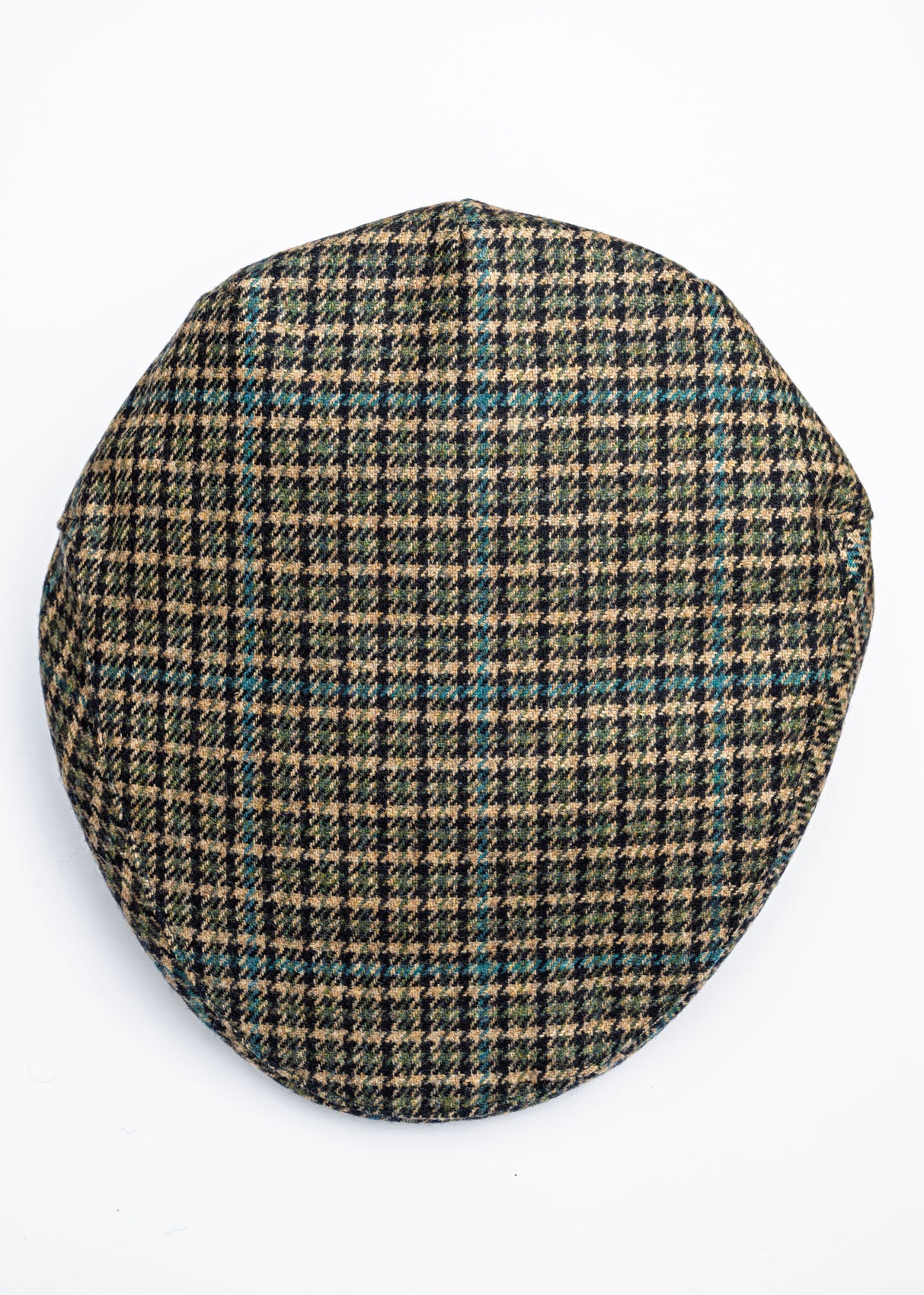Houndstooth patterned flat cap on a beige background
