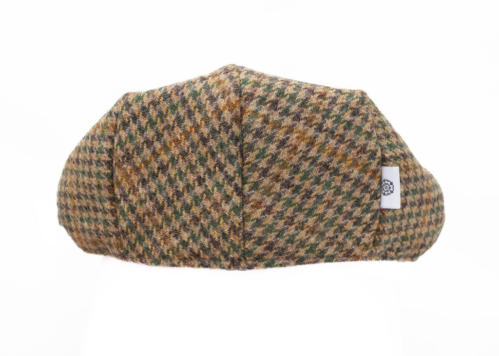 Houndstooth patterned flat cap with a brand label on a white background