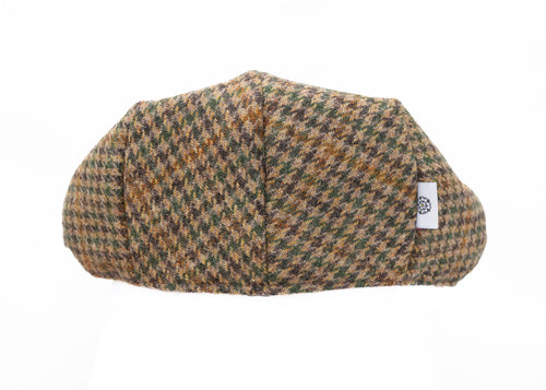 Houndstooth patterned flat cap with a brand label on a white background
