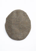 Herringbone patterned flat cap on a white background