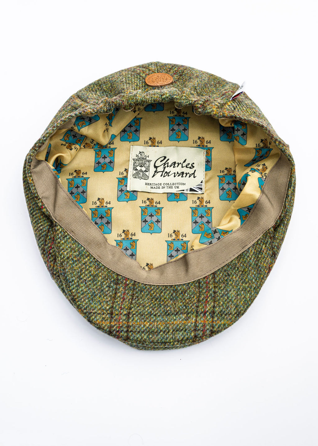 Green checkered flat cap with Yorkshire patterned interior and visible brand label on a white background