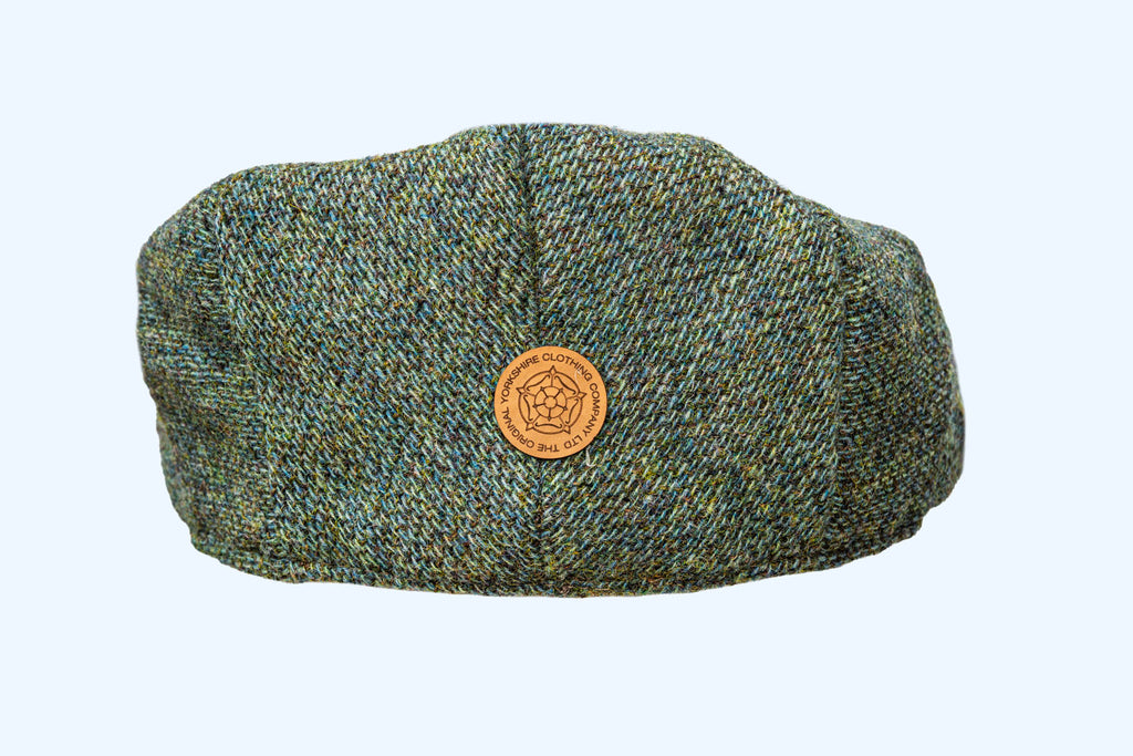 Green tweed cap with a logo on a light blue background